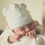 beba-novorođenče-na-ramenu-kapica