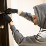 Burglar picking lock of a house